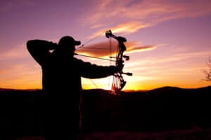 A bowhunter silhouetted against a beautiful sunset